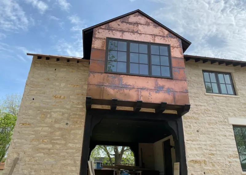 Copper metal panel facade on a stone building for Roof Repair in Raceland